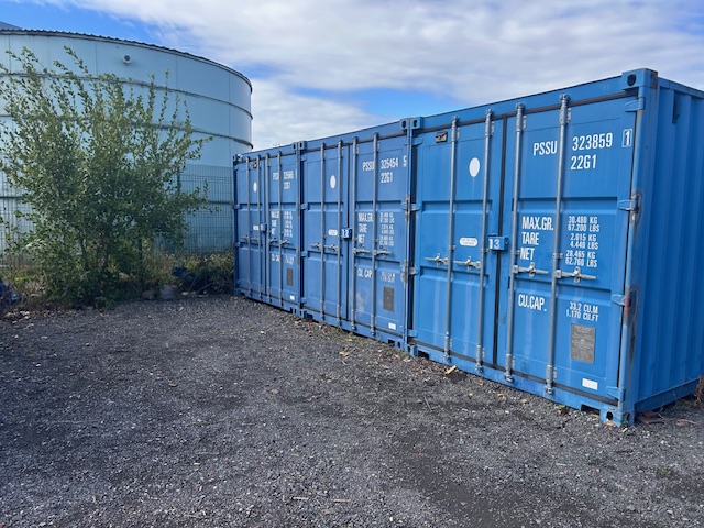 Multiple blue shipping containers at Benton Storage facility showing secure storage options